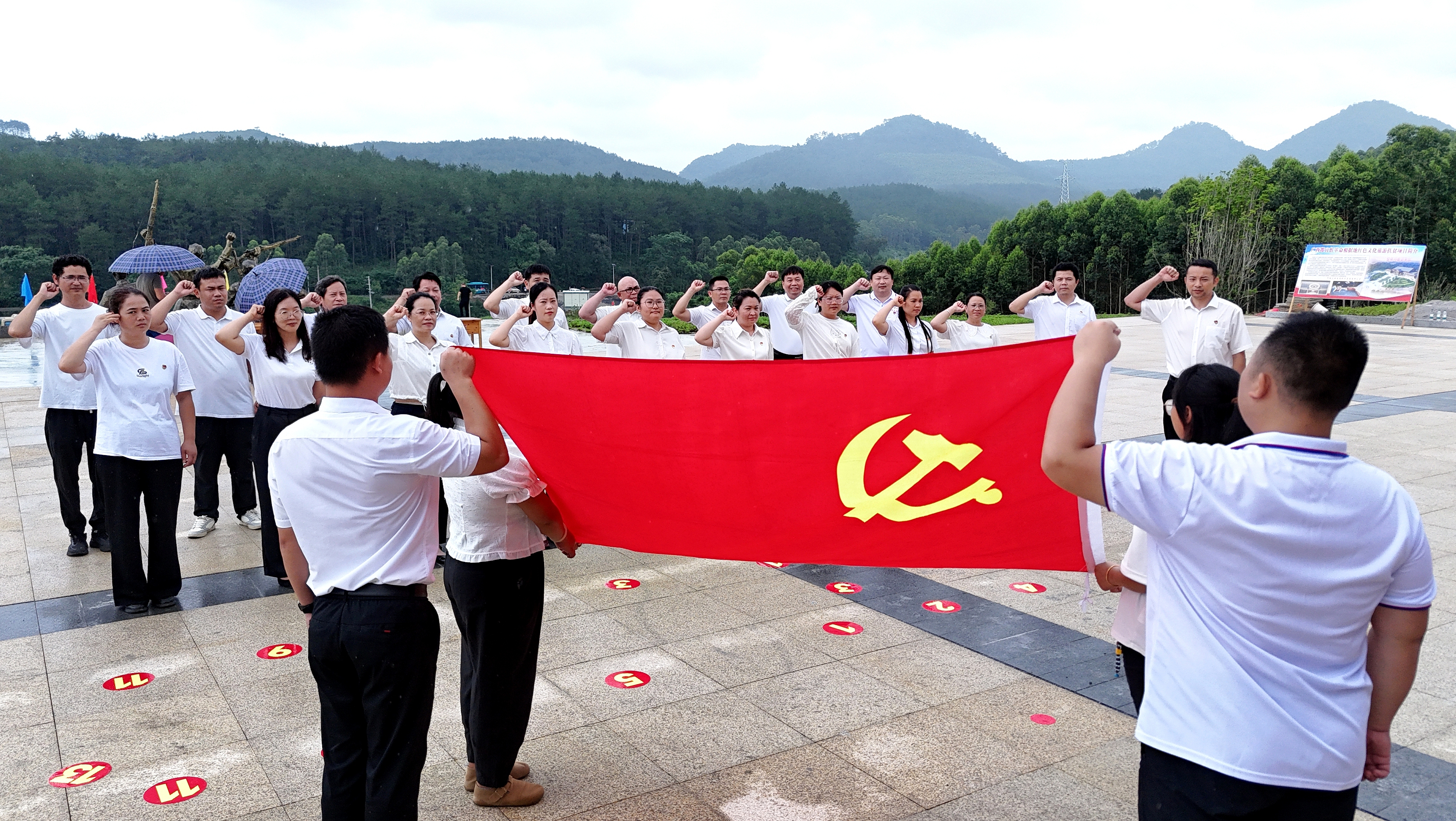 2025年7月1日，廣西都宜忻人民解放總隊紀念館前，黨員面向黨旗重溫入黨誓詞。